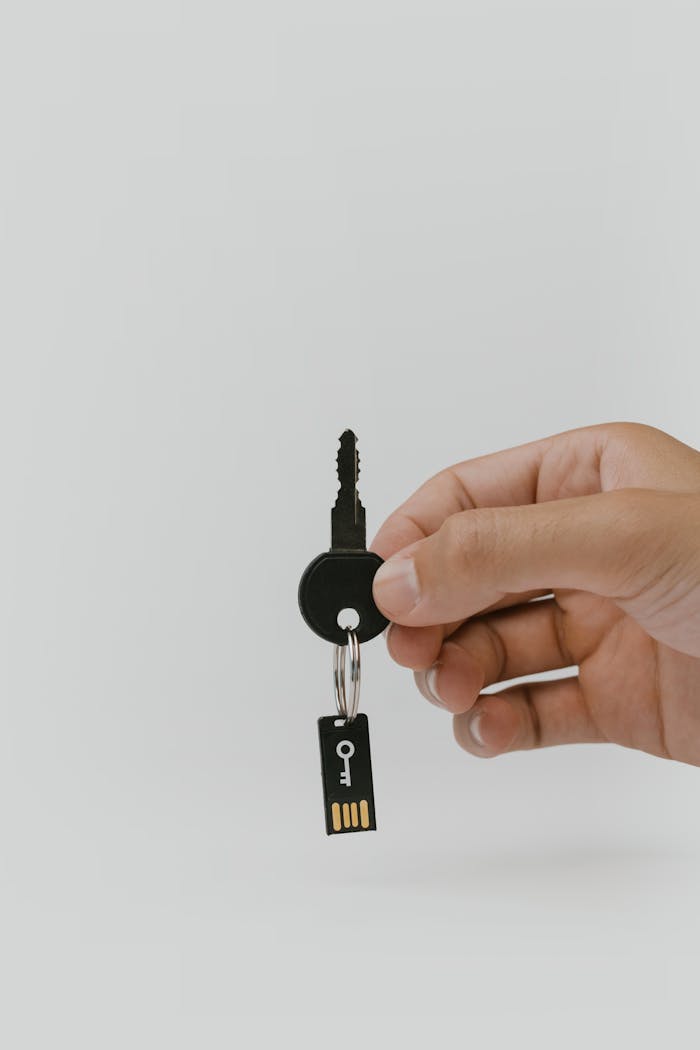 Close-up of a hand holding a key and USB with copyspace.
